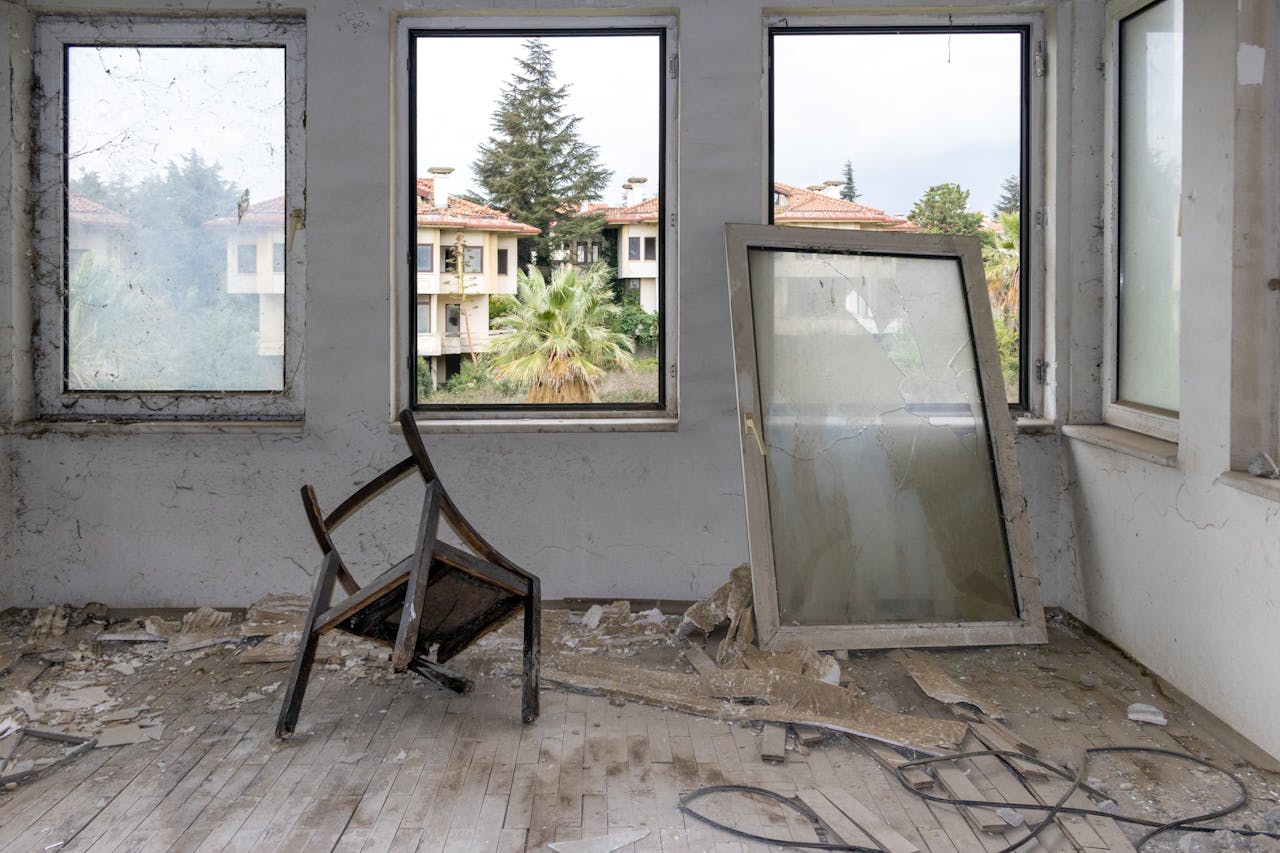 services-01 Desolate interior of an abandoned building with broken furniture and windows.