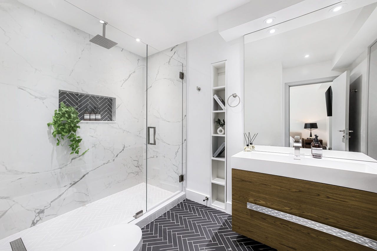 services-02 Elegant modern bathroom interior with a glass shower and marble walls.